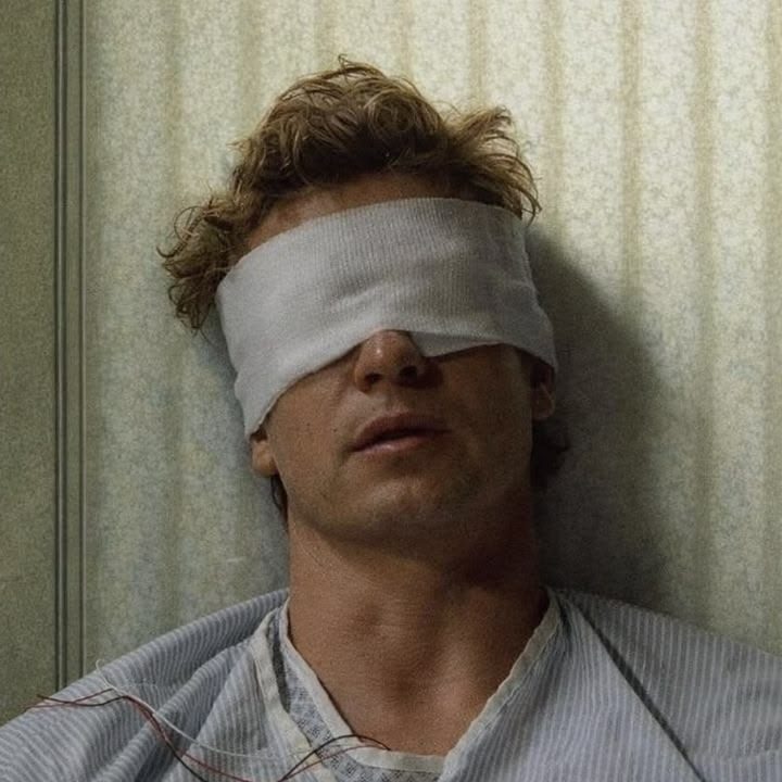 Patrick Jane blindfolded in a hospital bed, monitored and vulnerable.